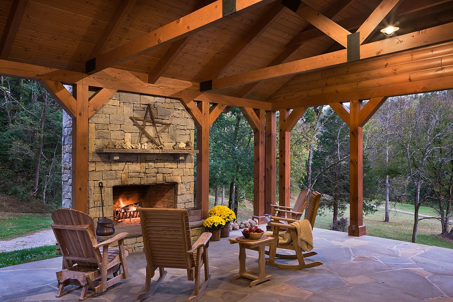 Photo of outdoor living space with fireplace and stone flooring