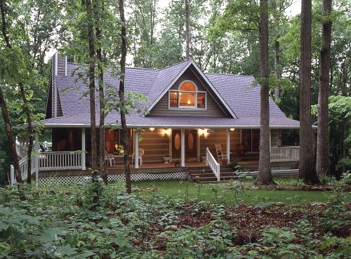 Log cabin with a-frame dormer over the entrance and a large front porch